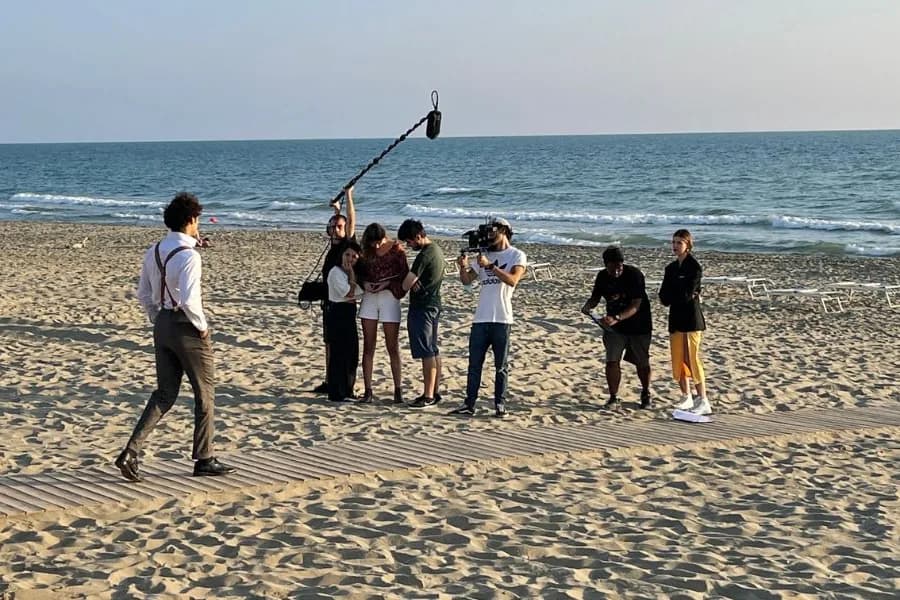 Piccolo gruppo al lavoro con la troupe in spiaggia