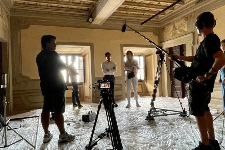 Un gruppo dietro la macchina da presa in una sala d'epoca