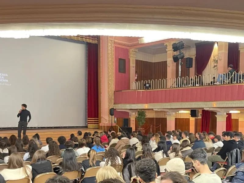 Sala di proiezione gremita, schermo acceso